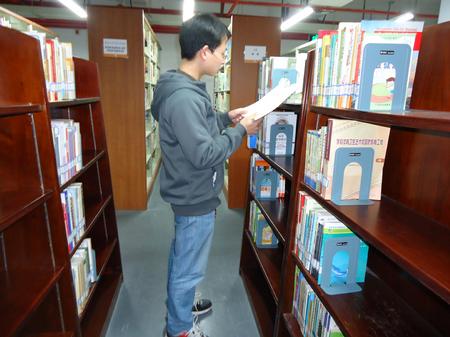 图为袁吉庆在图书馆看书